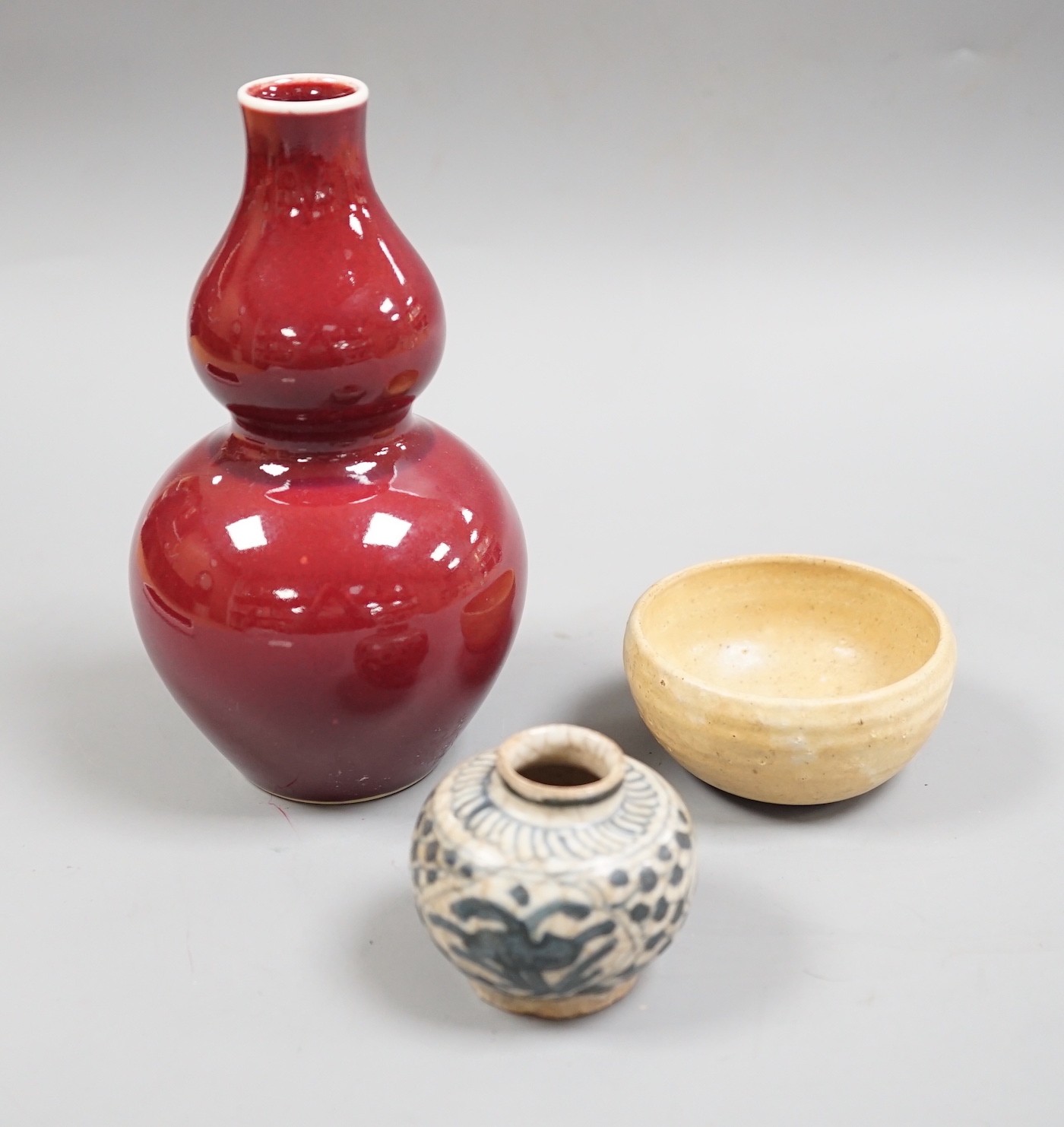 A Chinese sang de boeuf double gourd vase, a Swatow blue and white jarlet and a small cup, tallest 17cm